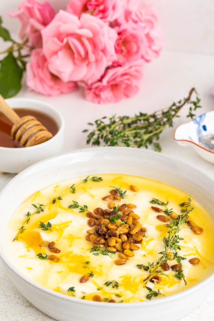 Whipped Ricotta in the bowl with roasted pinenuts, thyme, honey and lemon zest