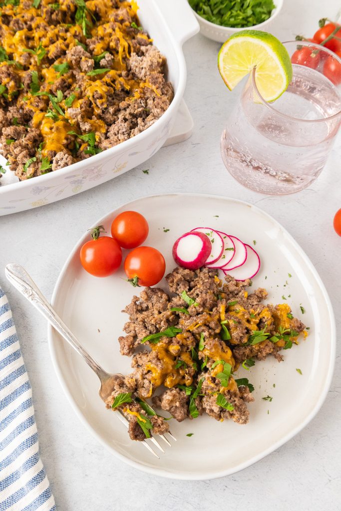 Ground beef on the plate with baking dish behind