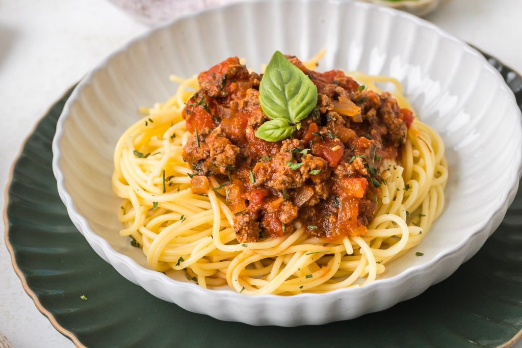 Italian Pasta Sauce with Ground Beef in the bowl over the cooked spaghetti.