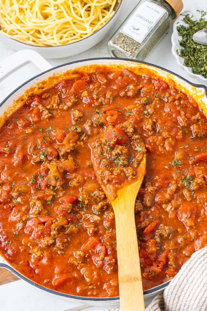 Italian Pasta made with ground beef in the pan with spatula in the middle.
