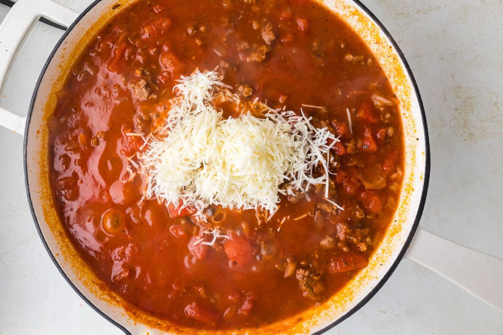 Parmesan cheese added to simmering pasta sauce.