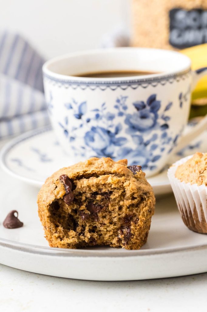 Banana chocolate chip muffins made with freshly milled flour, arranged on a cooling rack; golden-brown tops with visible melted chocolate chips.