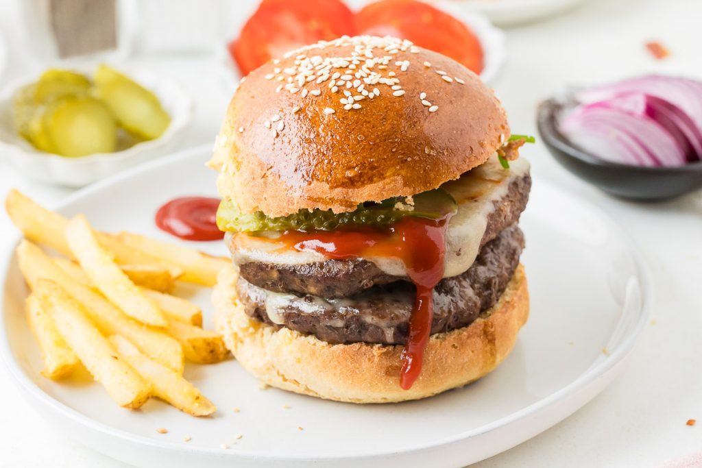 Soft homemade hamburger buns made with freshly milled flour, baked until golden brown and ready for burgers or sandwiches.