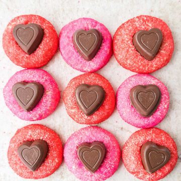 Soft sugar cookies coated in pink sanding sugar with chocolate hearts in the center