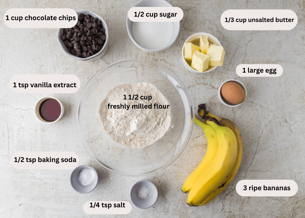 Ingredients for banana bread on the table - bananas, egg, butter, sugar, salt, baking soda, vanilla extract, chocolate chips