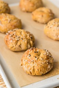 Homemade healthy bagels on a baking sheet with a soft and chewy texture.