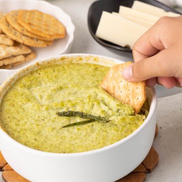 Creamy baked asparagus dip made with asparagus, Parmesan, and yogurt, served warm for dipping.