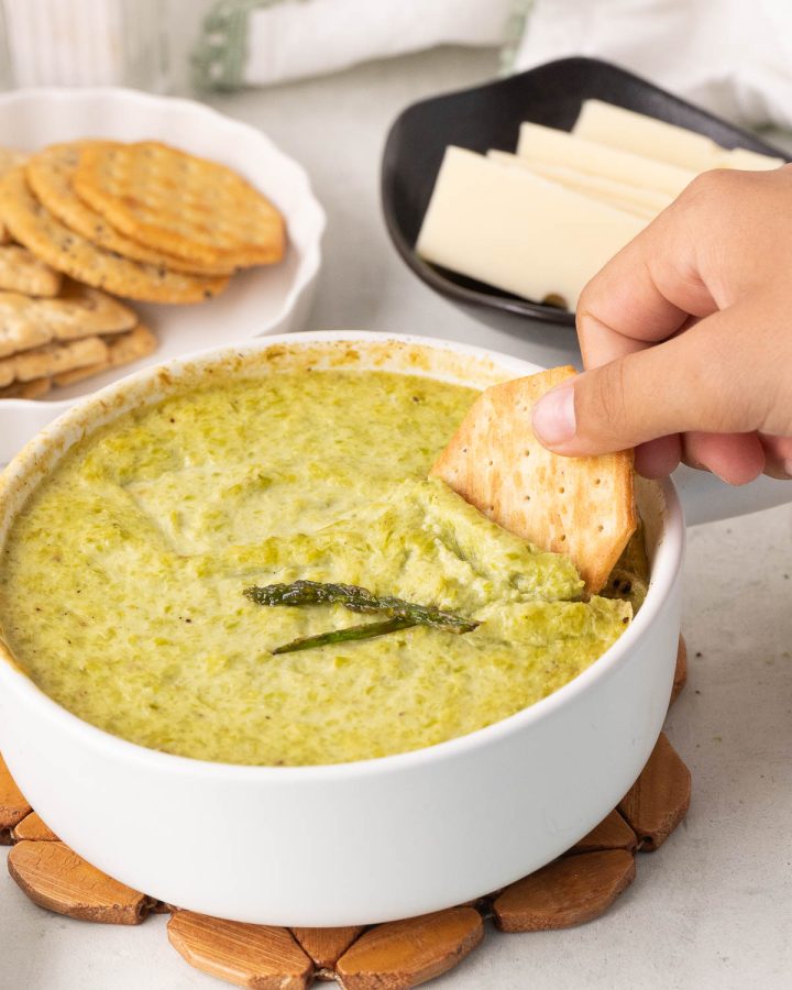 Creamy baked asparagus dip made with asparagus, Parmesan, and yogurt, served warm for dipping.