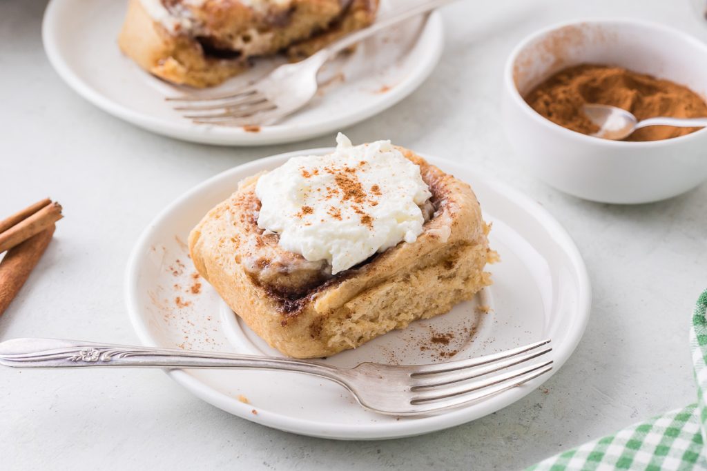 two plates with freshly milled flour cinnamon rolls on each plate