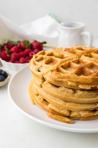 Freshly milled flour waffles served with fresh berries and maple syrup